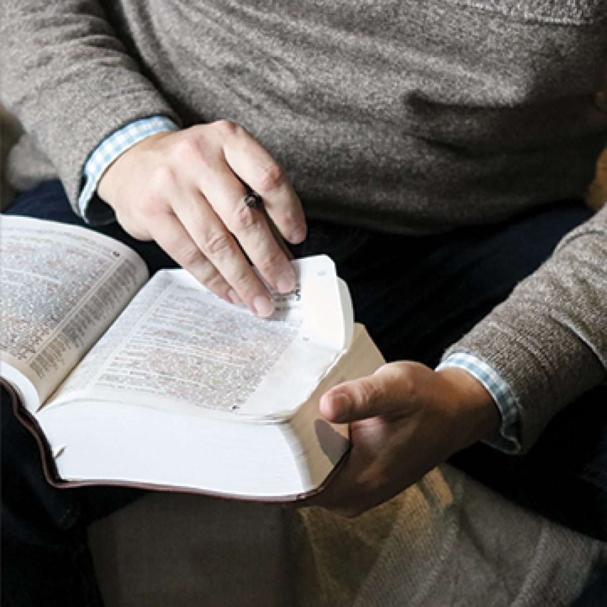Man flipping the pages of his Bible