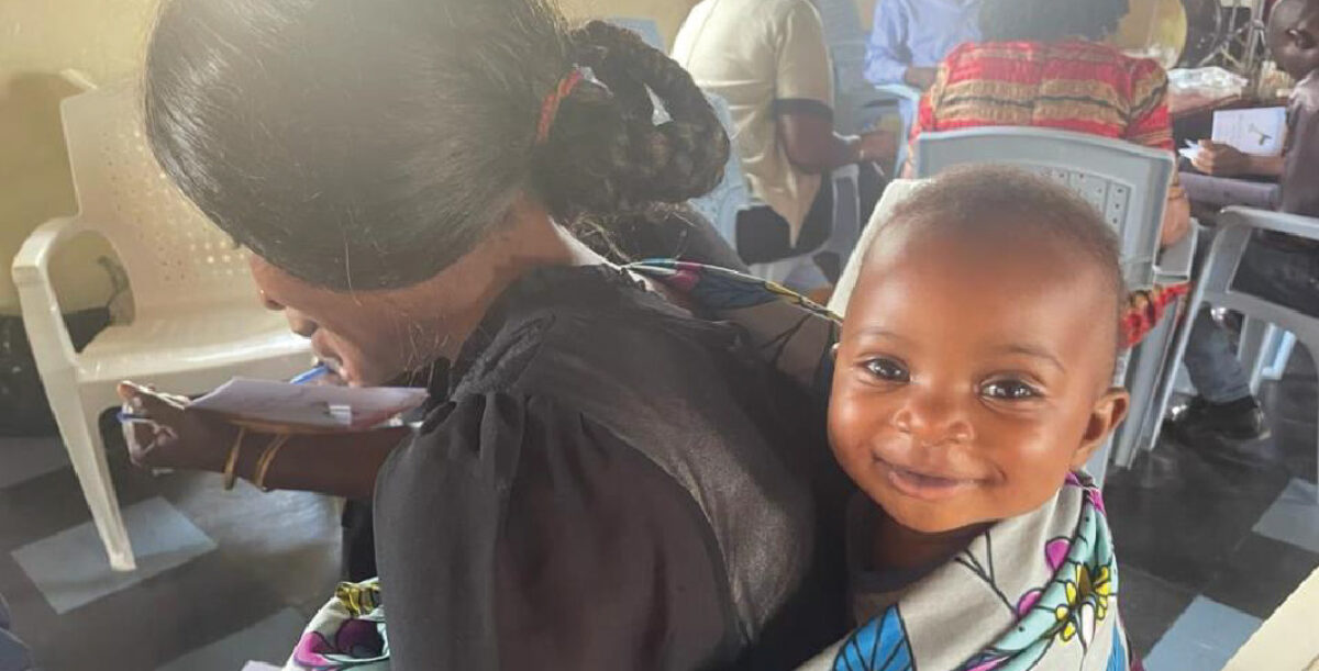 A mother with her baby at a Bible study training in Kitale